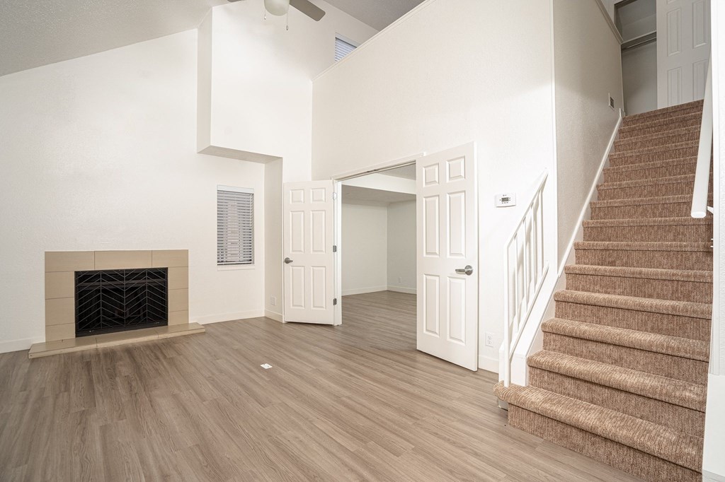 a living room with stairs and a fireplace